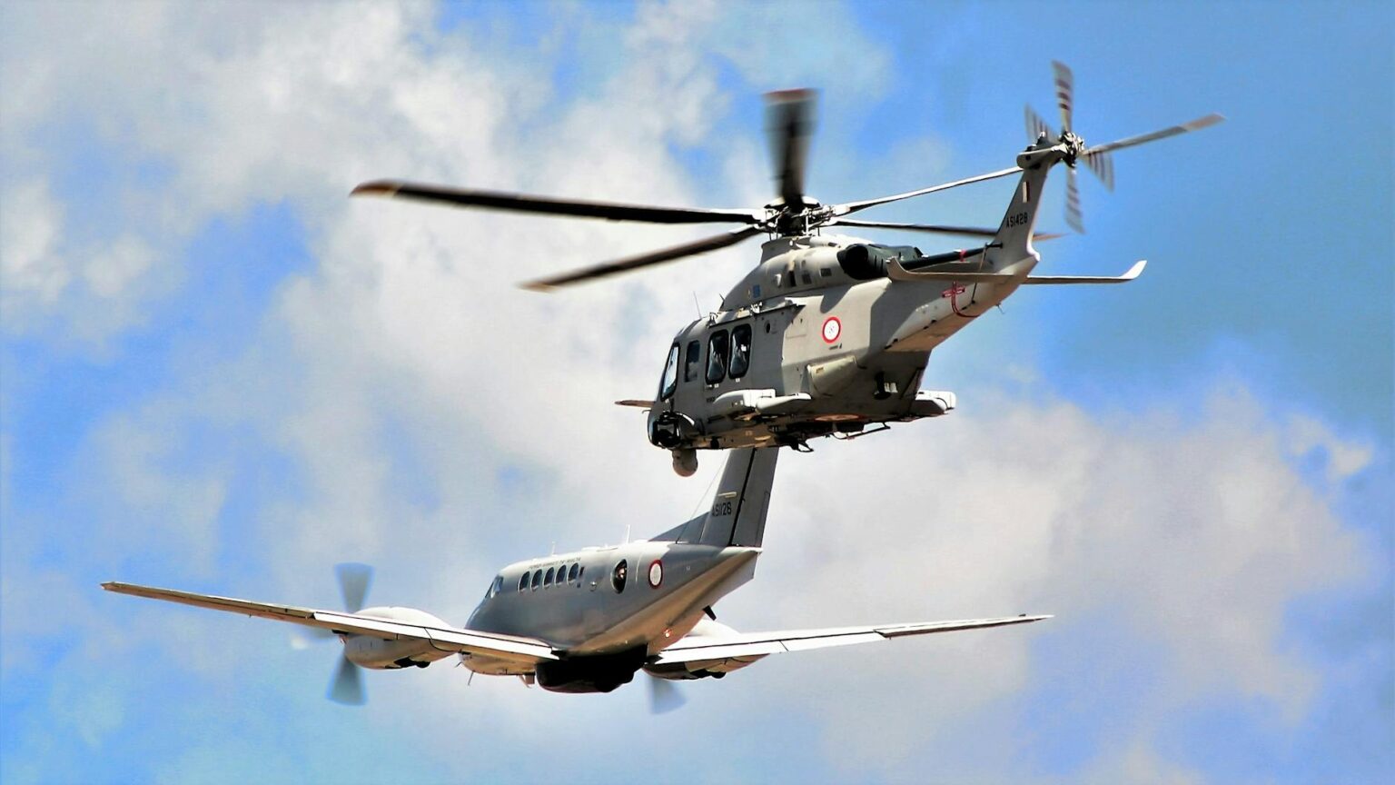 helicopter and airplane flying in formation